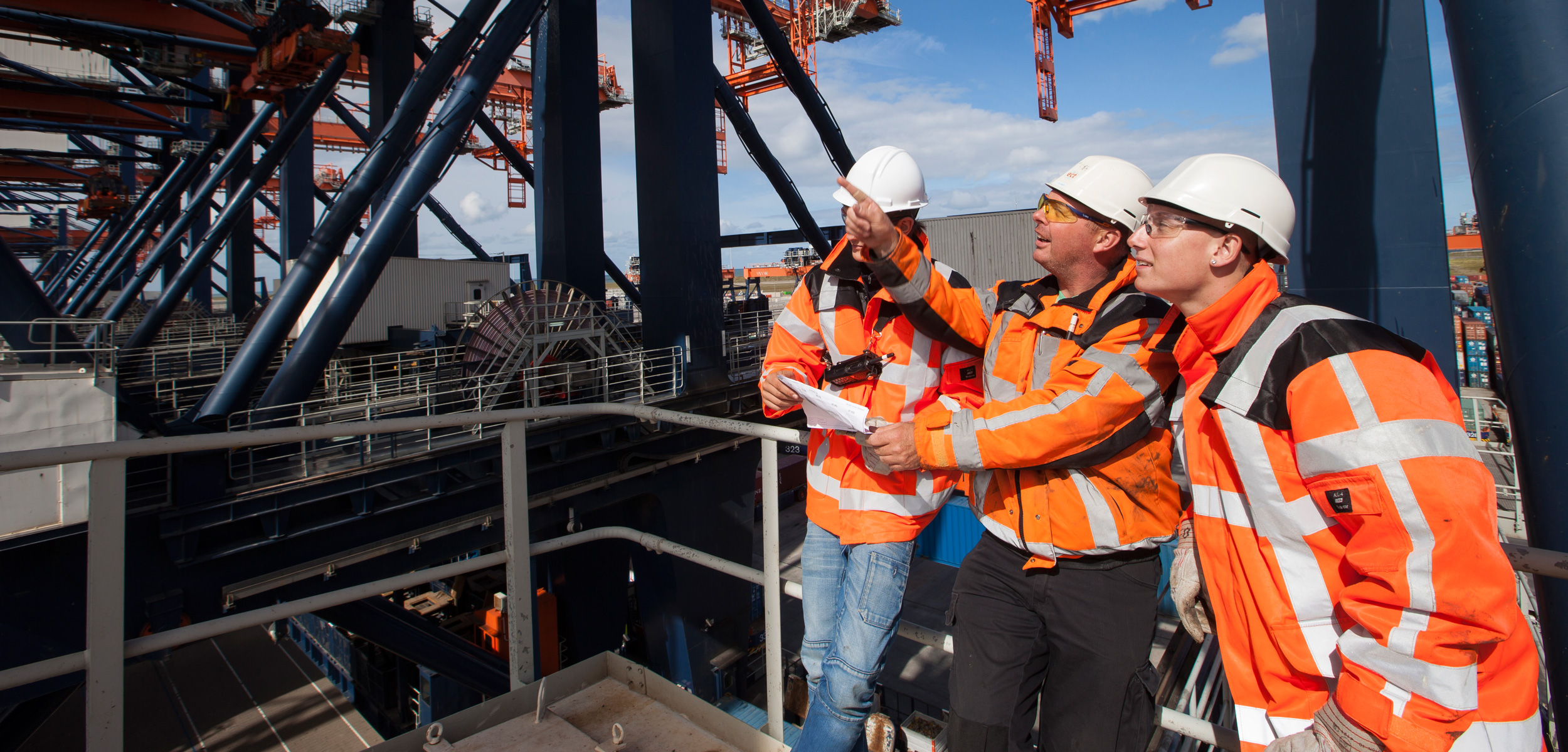Foto van drie medewerkers op de kraan van Hutchison Ports ECT Rotterdam